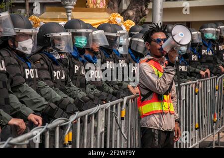 Bangkok, Thailand. 13th Mar, 2021. A protester speaks on megaphone in front of riot policemen during the demonstration.The pro-democracy protesters gather at the Democracy Monument before marching to the Government house of Thailand to demand the reform of the monarchy and abolish the lese majesty law (article 112 of the Thai criminal code) and reassignment of Thailand's Prime Minister Prayut Chan-o-cha (Photo by Peerapon Boonyakiat/SOPA Images/Sipa USA) Credit: Sipa USA/Alamy Live News Stock Photo