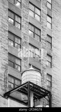 Black and white picture of water tower on a roof of an old building in Manhattan, New York City, USA. Stock Photo