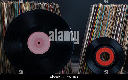 two records (single and Long Play) lean against a pile of records Stock Photo