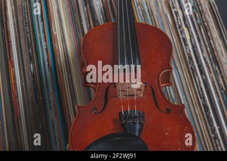 a violin in front of a pile of old vinyl records Stock Photo