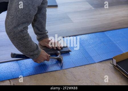 Renovation works craftsman improvement man with a using hammer the installing laminate flooring Stock Photo