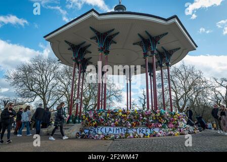 London, UK.  13 March 2021.  People lay floral tributes at the bandstand on Clapham Common to remember Sarah Everard.  Wayne Couzens, 48, a serving Met Police officer, has been charged with her kidnap and murder after she walked home close to Clapham Common in south London.  The 33-year-old's body was found in woodland in Kent more than a week after she was last spotted on 3 March.  Credit: Stephen Chung / Alamy Live News