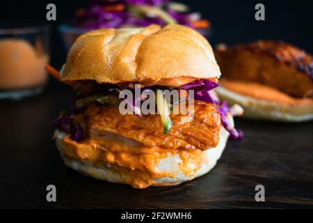 Asian Salmon Sandwich with Sesame Slaw: A broiled salmon sandwich topped with sesame slaw and sriracha mayonnaise Stock Photo