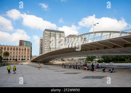 A group of people is doing a yoga lesson in the Turia Park in Valencia, Spain. Jardi del Turia is a big and modern park that crosses the city center Stock Photo