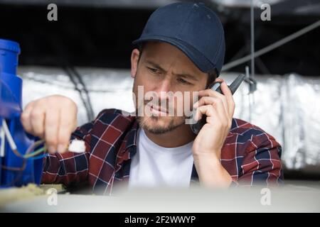 electrician installing ventilation in ceiling Stock Photo