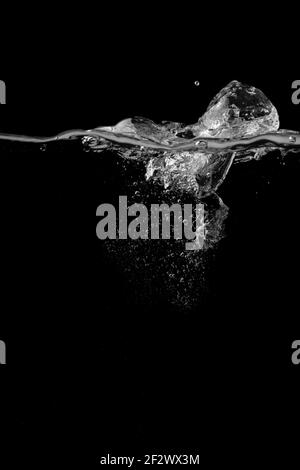 Splashing and bubbles on a clear water liquid surface. Isolated on a black Stock Photo
