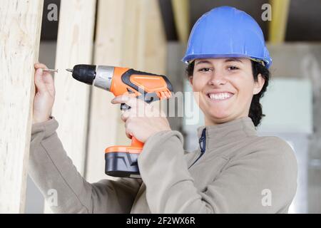 female builder using electric screwdriver in wood Stock Photo
