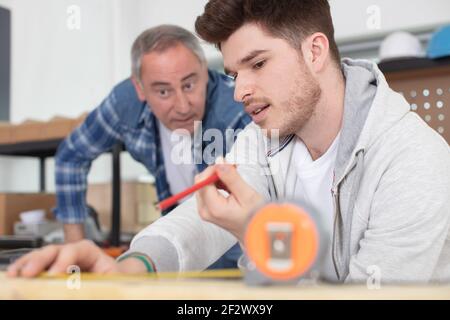 carpenter with apprentice in training period Stock Photo