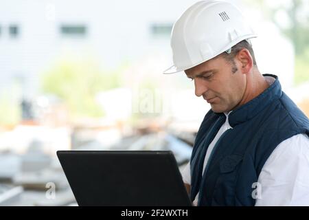 engineer working with laptop outdoors Stock Photo