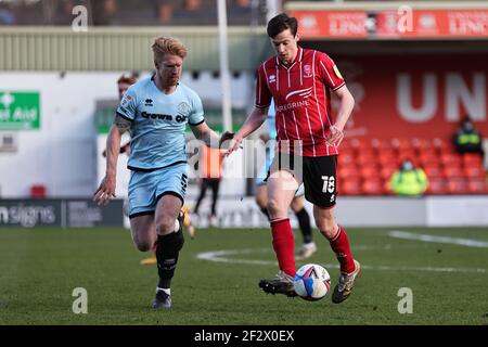 LINCOLN, UK. MARCH 13TH: Conor McGrandles of Lincoln City (R) and Paul Mcshane of Rochdale in action during the Sky Bet League 1 match between Lincoln City and Rochdale at LNER Stadium, Lincoln on Saturday 13th March 2021. (Credit: James Holyoak | MI News) Credit: MI News & Sport /Alamy Live News Stock Photo