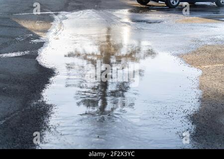 Thawing patch of ice in car parking lot Stock Photo