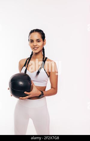 Smiling mixed race woman holding a medicine ball Stock Photo
