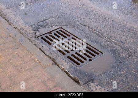 Stormwater storm on the sidewalk road close up Stock Photo