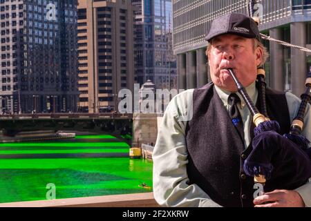 Chicago, IL, USA. 13th Mar, 2021. Chris Coomes plays bagpipes ahead of St. Patrick's Day along the Chicago River, dyed green every year to honor the city's Irish American heritage. Credit: Dominic Gwinn/ZUMA Wire/Alamy Live News Stock Photo