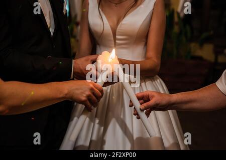 Wedding traditions family lights. Candle in the hands of the newlyweds Stock Photo