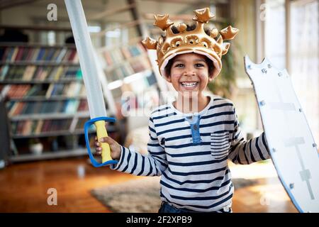 A cute little boy with sweet smile is posing for a photo while playing in a cheerful atmosphere at home. Family, together, love, playtime Stock Photo