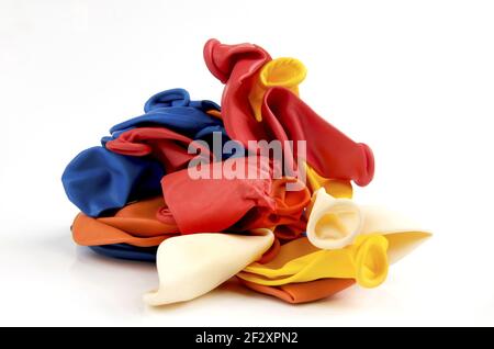 A pile of colorful deflated balloons isolated on a white background Stock Photo