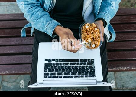 Focused African American male designer using graphic tablet with stylus and looking at screen of netbook while working on project in cafe Stock Photo