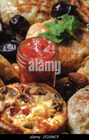 From above of tasty manakish near assorted Moroccan food with salsa and dried dates during Ramzan holidays Stock Photo