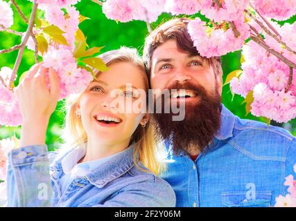 Relationship concept. Happy Couple near blossoming Sakura. Smiling family spend time in spring garden. Stock Photo