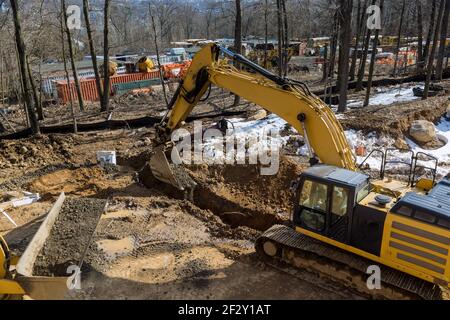 Construction of drain system with trench under construction road Stock Photo