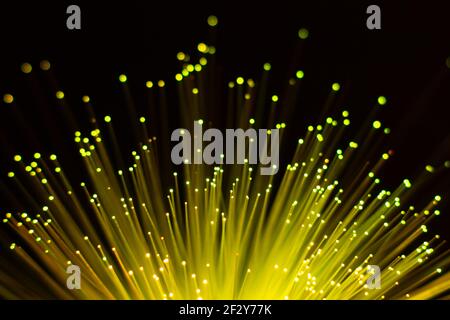 yellow fan-shaped fiber optic lights with defocused dots on black background Stock Photo