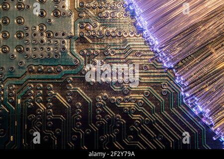 super macro of printed circuit illuminated by blue fiber optic lines with warm tones Stock Photo