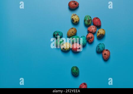 colored painted eggs scattered on a blue background for easter Stock Photo