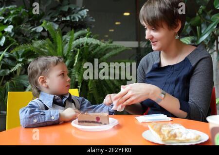 Mother cleans her son's hand in the cafe Stock Photo