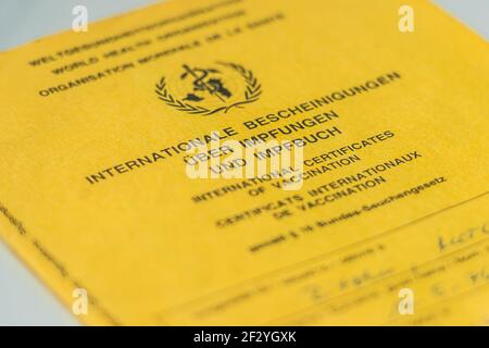 Cover page of the World Health Organization's international vaccination card. Yellow vaccination certificate with proof of vaccinations. Travel docume Stock Photo