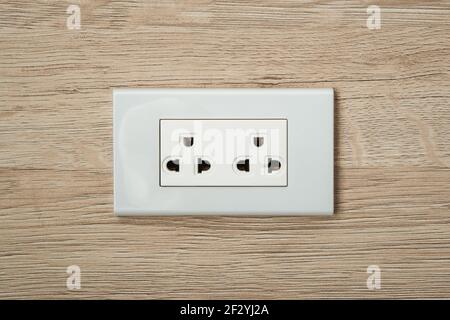 AC power plugs and sockets in wooden wall. Stock Photo