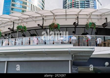 Brisbane, Queensland, Australia - March 2021: People dining at a city restaurant with high rises in the background Stock Photo