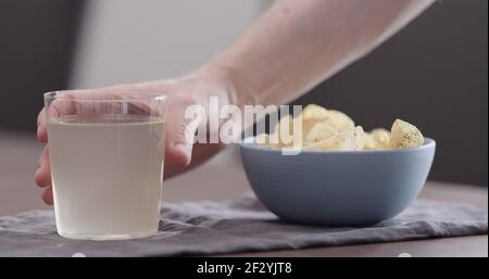 man take potato chips with ground pepper and salt and drink ginger beer, wide photo Stock Photo