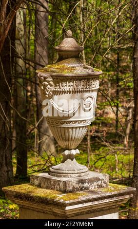 The Friendship Urn - a decorative stone urn on a plinth, in a forest garden. New England Botanic Garden at Tower Hill, Boylston, Massachusetts Stock Photo