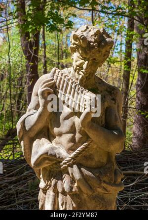 Statue of Pan playing his flute. Pan is the Greek god of the wild, shepherds and flocks, rustic music and impromptus. New England Botanic Garden, MA Stock Photo