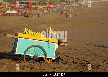 Cart of a street vendor with roasted corn for sale on a sandy beach - Bali, Indonesia Stock Photo