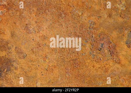 The texture of an old metal surface covered with loose yellow-brown rust. Stock Photo