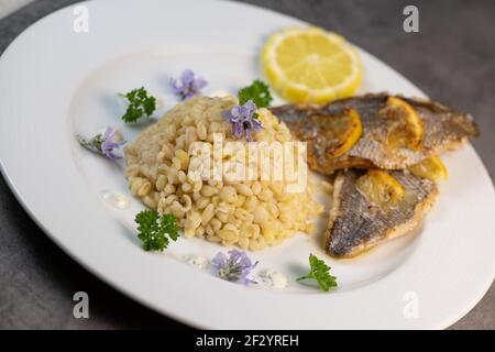 Lemon-spiked sea bream fillet, cooked wheat risotto  Stock Photo