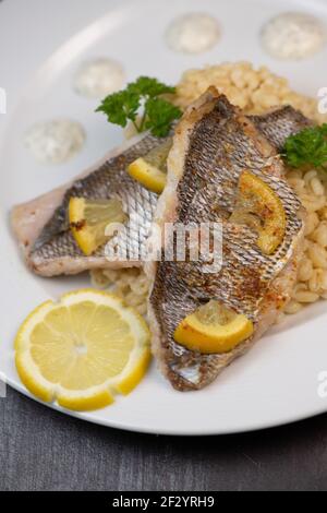 Lemon-spiked sea bream fillet, cooked wheat risotto  Stock Photo