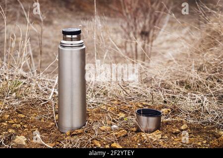 Steel vacuum thermos with tea or coffee, outdoor. Hiking, active tourism,  picnic, hot drink concept Stock Photo - Alamy