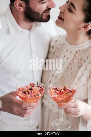 Happy couple holding glasses of sparkling champagne cocktail in hands Stock Photo