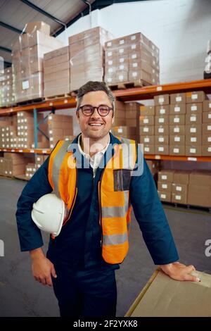 Portrait of a happy male engineer with safety hardhat and in black eyeglasses Stock Photo