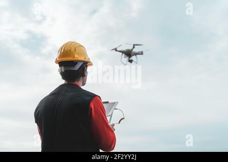 Male engineer monitoring construction site with drone - Technology and industrial concept Stock Photo