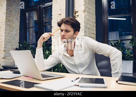 Focused businessman working on laptop in office Stock Photo