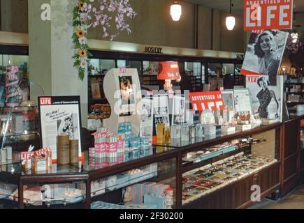 A display counter in an American department store c. 1955. The display features products advertised in ‘Life’ magazine, mainly aimed at the beauty market. ‘Life’ was a famous American magazine published weekly from 1883 to 1972, with intermittent issues until 1978, and as a monthly from 1978 until 2000. During its golden age from 1936 to 1972, it was a wide-ranging, general interest magazine well-known quality photography and the distinctive red masthead on its cover. This image is from an old American amateur colour transparency a vintage 1950s photograph. Stock Photo