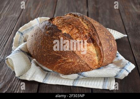 Rustic sourdough bread with a crisp crust on a kitchen towel close-up Stock Photo