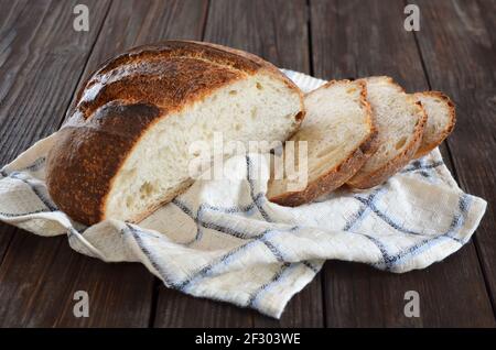 Sliced homemade bread with a crisp crust on a kitchen towel close-up Stock Photo