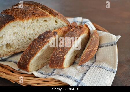 Close-up of sliced homemade bread with a crisp crust on a kitchen towel, selective focus Stock Photo