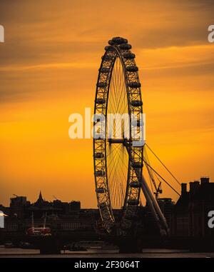 London UK February 2021 Amazing late sunset over London, silhouettes of the buildings and the London eye contrasting the dark orange sky. Red double d Stock Photo