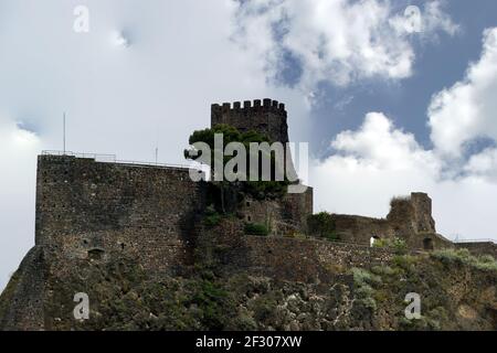 A medieval castle built on a steep rock formation overhanging on the Ionian sea. Acicastello, close to Catania; Sicily. Italy. Stock Photo
